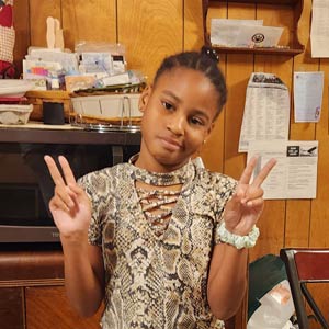 Photo of a young girl flashing peace signs