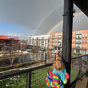 Photo of a child pointing to a rainbow