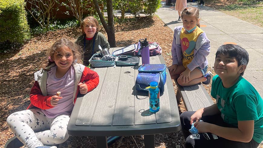 Photo of children at Sandy Ridge Elementary eating lunch outside